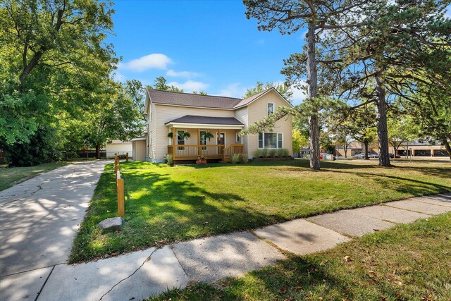 view of front of house featuring a garage, covered porch, and a front yard