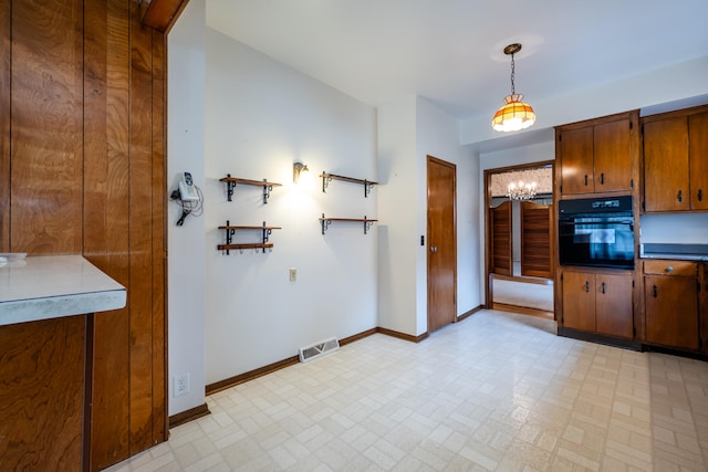 kitchen featuring black oven and hanging light fixtures