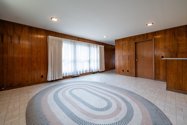 unfurnished room featuring wooden walls