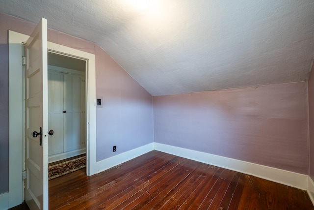 bonus room with a textured ceiling, lofted ceiling, and dark hardwood / wood-style flooring