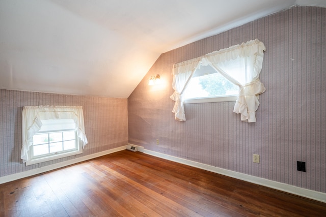 additional living space featuring wood-type flooring and vaulted ceiling