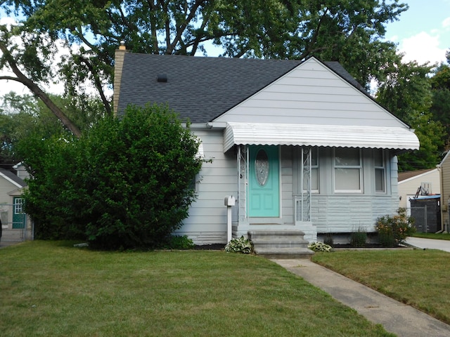 bungalow-style home with a front lawn