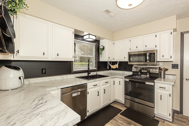 kitchen featuring white cabinetry, appliances with stainless steel finishes, and sink