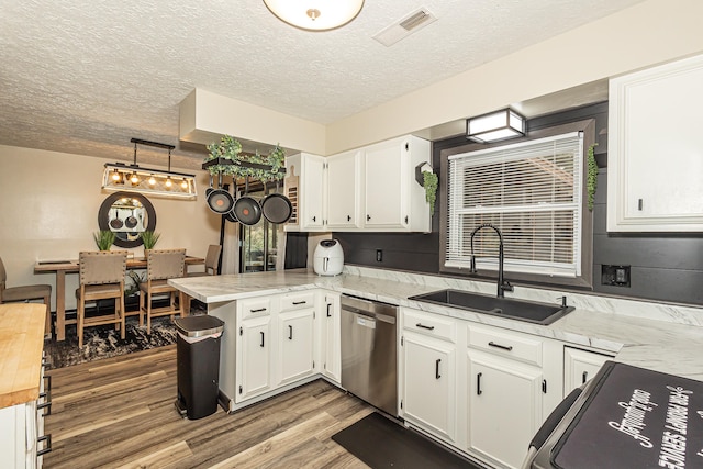 kitchen featuring light hardwood / wood-style floors, kitchen peninsula, white cabinetry, and sink