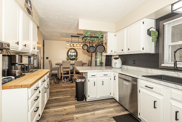 kitchen featuring dark hardwood / wood-style flooring, white cabinets, kitchen peninsula, and stainless steel dishwasher