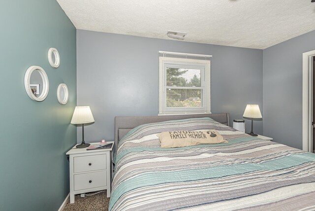 carpeted bedroom featuring a textured ceiling