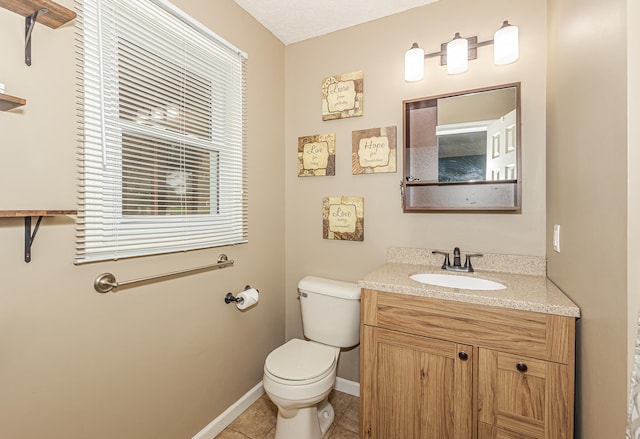 bathroom with vanity, toilet, and tile patterned floors