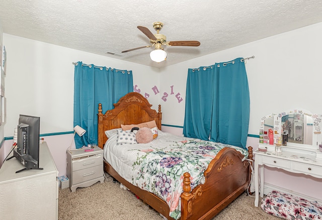 carpeted bedroom featuring a textured ceiling and ceiling fan