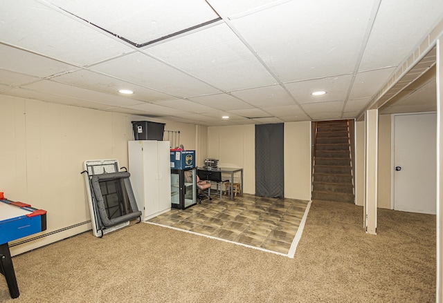 basement featuring carpet, a drop ceiling, and a baseboard radiator