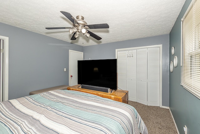 carpeted bedroom with a textured ceiling, ceiling fan, and a closet