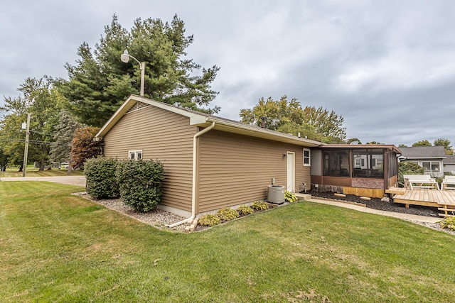 exterior space with a deck, a sunroom, and a yard