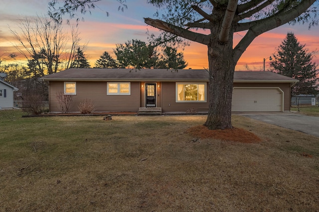 ranch-style home featuring a garage and a lawn