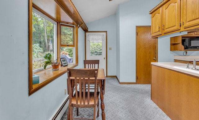 carpeted dining space with vaulted ceiling