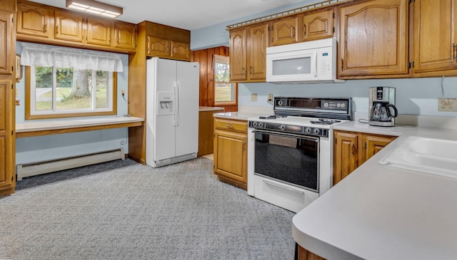 kitchen featuring a healthy amount of sunlight, white appliances, light colored carpet, and a baseboard radiator