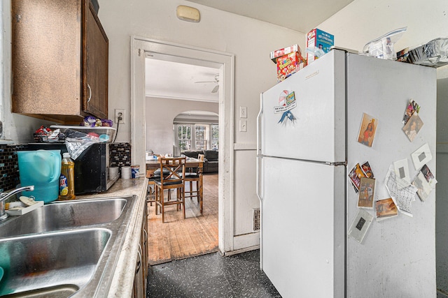 kitchen with ceiling fan, white refrigerator, sink, dark hardwood / wood-style floors, and crown molding