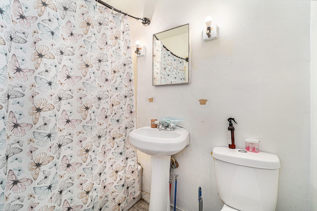 bathroom with toilet and a shower with shower curtain