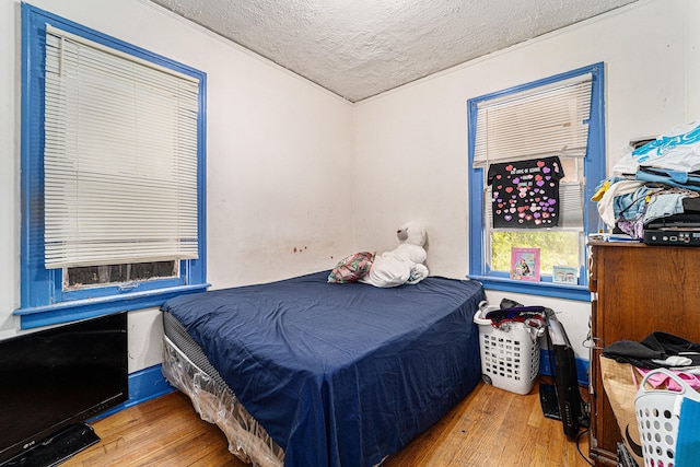 bedroom with a textured ceiling and hardwood / wood-style floors