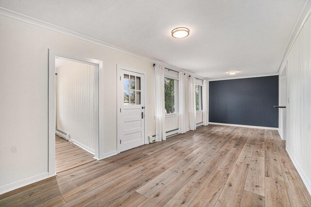 3143 US 31 N, Conway, MI 49722 - entryway featuring baseboards, ornamental molding, baseboard heating, and light wood finished floors