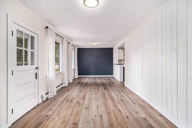 3143 US 31 N, Conway, MI 49722 - interior space featuring ornamental molding, baseboards, light wood-style floors, and baseboard heating