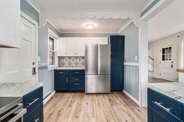 3143 US 31 N, Conway, MI 49722 - kitchen with white cabinetry, light wood-style flooring, blue cabinets, and freestanding refrigerator
