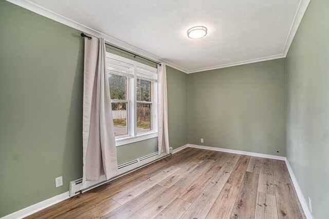 3143 US 31 N, Conway, MI 49722 - unfurnished room with baseboards, crown molding, light wood-style flooring, and baseboard heating