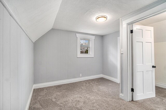 3143 US 31 N, Conway, MI 49722 - additional living space with baseboards, vaulted ceiling, carpet, and a textured ceiling
