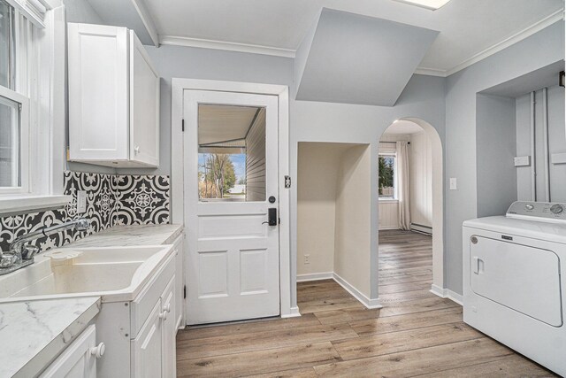 3143 US 31 N, Conway, MI 49722 - clothes washing area with crown molding, washer / clothes dryer, arched walkways, a sink, and light wood-type flooring