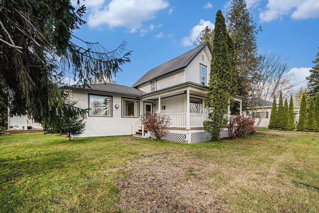 3143 US 31 N, Conway, MI 49722 - view of front of house featuring covered porch, a front yard, and a shingled roof