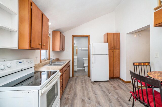 3143 US 31 N, Conway, MI 49722 - kitchen featuring white appliances, vaulted ceiling, brown cabinets, and a sink