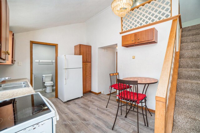 3143 US 31 N, Conway, MI 49722 - kitchen with light countertops, white appliances, a sink, light wood-style floors, and vaulted ceiling