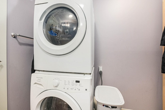 clothes washing area with stacked washer and clothes dryer