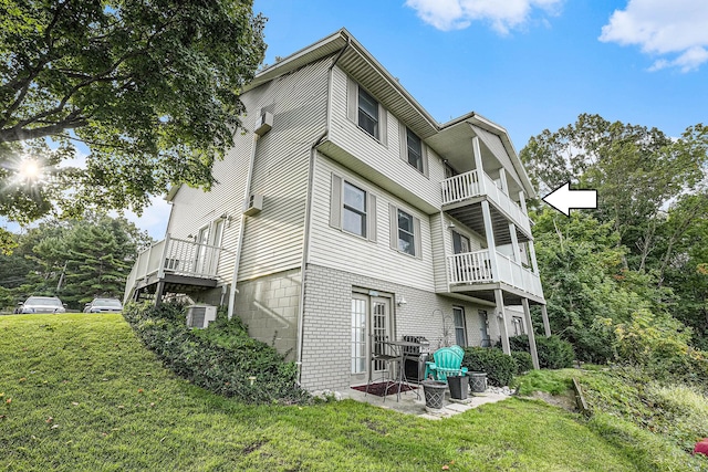 back of house featuring a balcony, a yard, a patio area, and central AC