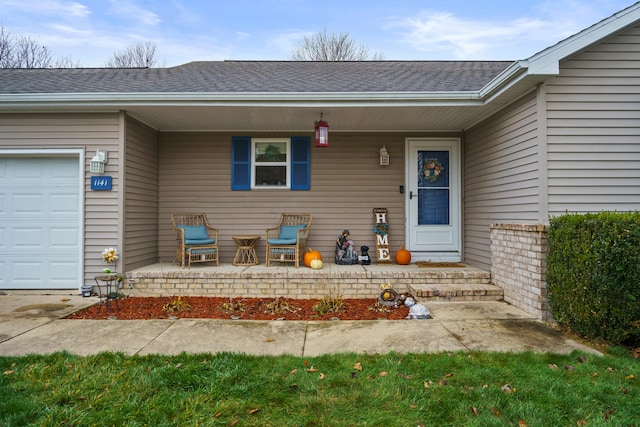 view of exterior entry featuring a porch and a garage