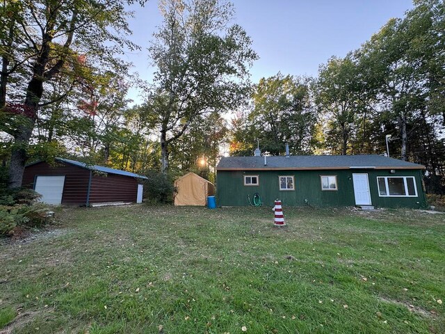 rear view of house with a yard and an outdoor structure