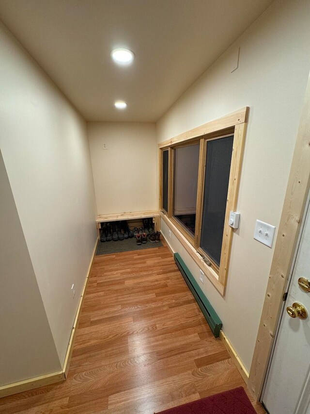 hallway featuring a baseboard radiator and light hardwood / wood-style flooring