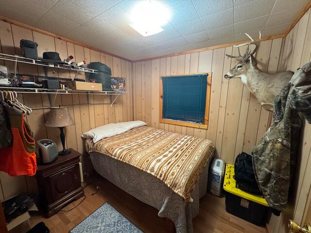 bedroom with wooden walls and hardwood / wood-style floors