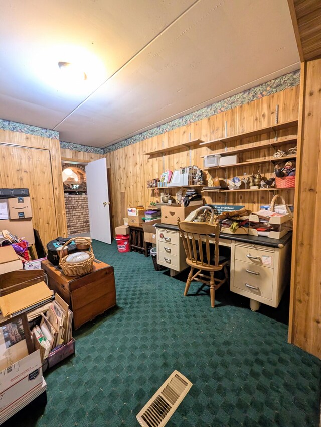 carpeted home office featuring wooden walls