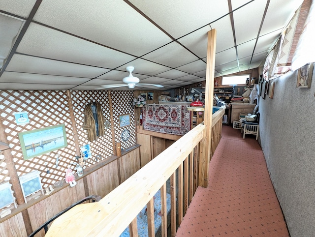 hall featuring carpet and a paneled ceiling