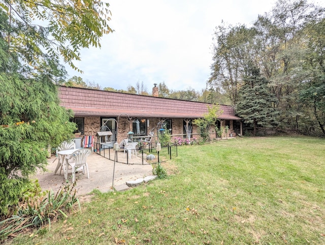 back of property featuring a patio area and a yard