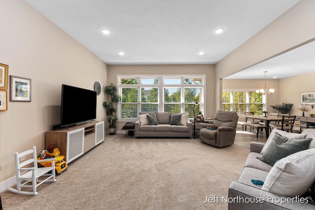 carpeted living room featuring an inviting chandelier