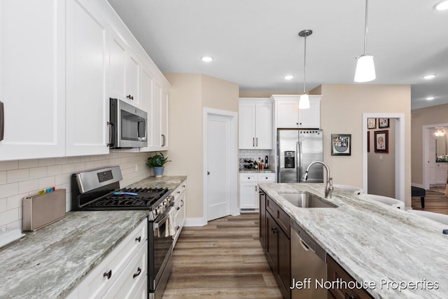 kitchen featuring dark hardwood / wood-style floors, sink, white cabinets, stainless steel appliances, and light stone countertops