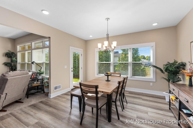 dining space with an inviting chandelier and light wood-type flooring