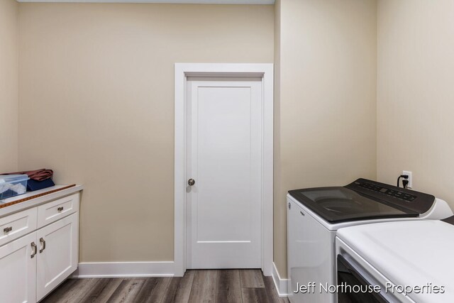 washroom with washer and clothes dryer, cabinets, and dark hardwood / wood-style floors