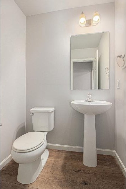 bathroom with toilet and wood-type flooring