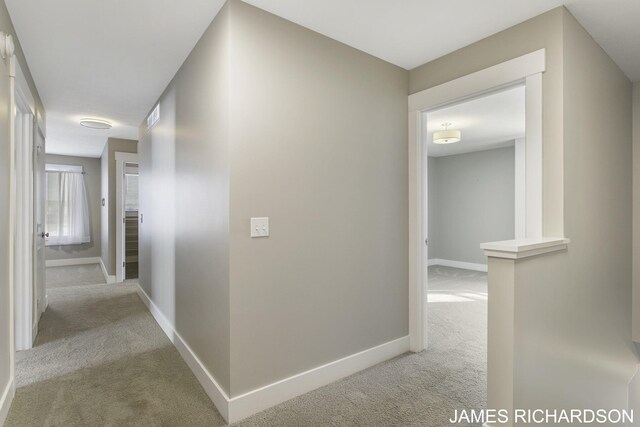 hall featuring light colored carpet