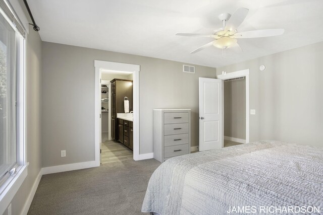 carpeted bedroom with ceiling fan and ensuite bathroom