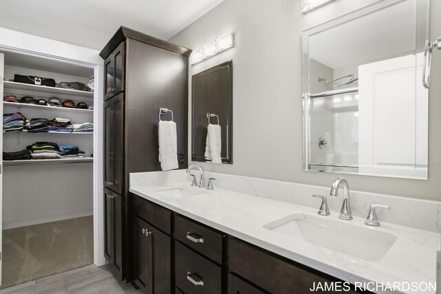 bathroom featuring wood-type flooring, vanity, and a shower with door