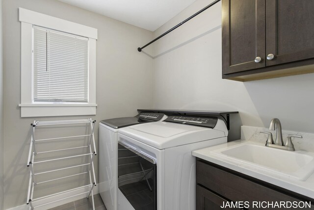 clothes washing area with washer and clothes dryer, cabinets, tile patterned flooring, and sink