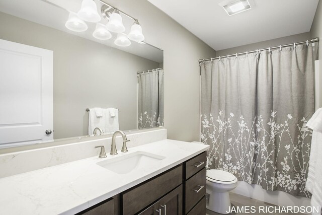 full bathroom featuring shower / tub combo, vanity, and toilet