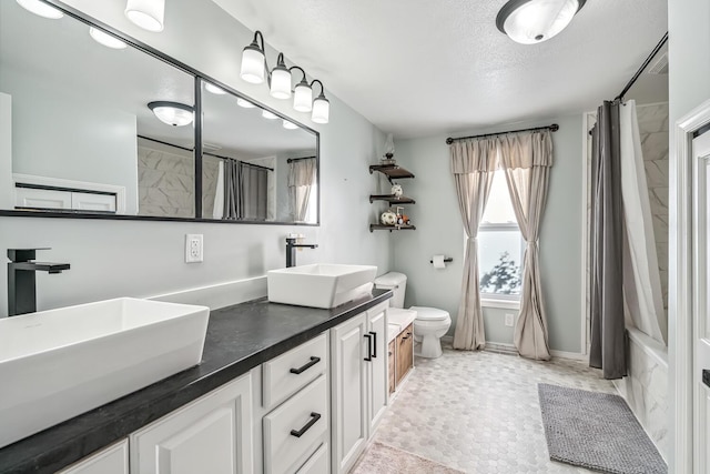 full bathroom with vanity, toilet, shower / bath combo with shower curtain, and a textured ceiling